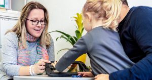 Ett barn och två vuxna använder Digitala Samtal på en surfplatta under ett möte