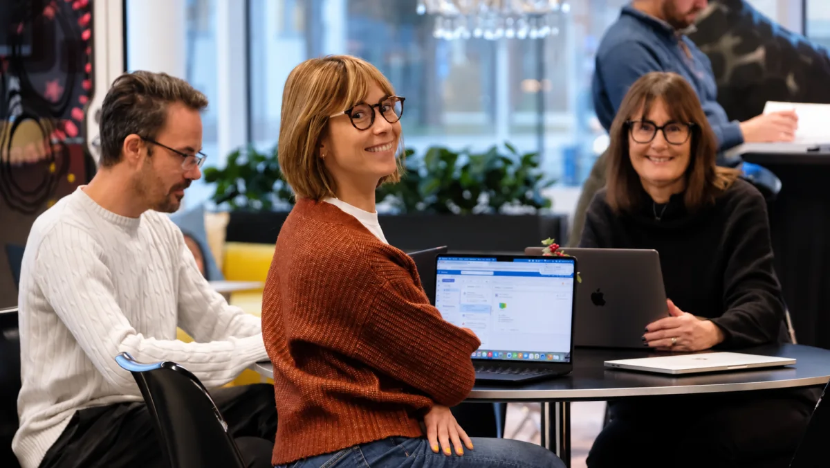 Kollegor på Digitala Samtal samtalar vid ett bord med bärbara datorer